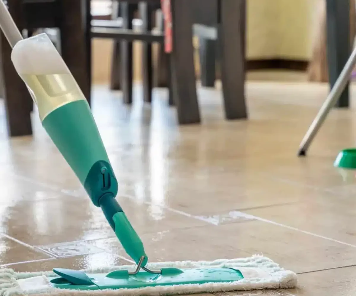 a-man-cleans-the-tiled-floor-in-an-apartment-with-a-compact-mop-with-a-reservoir-of-detergent-scaled